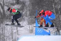 epa09748459 Nick Baumgartner of the USA (left) leads Eliot Grondin of Canada and Omar Visintin of Italy (right) at the final jump in the big final during the Mixed Team Snowboard Cross at the Genting Snow Park, during the 2022 Beijing Winter Olympic Games, in Beijing, China,  12 February 2022.  EPA/DAN HIMBRECHTS  AUSTRALIA AND NEW ZEALAND OUT