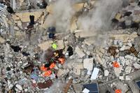 This aerial view shows residents helped by bulldozers, searching for victims and survivors in the rubble of collapsed buildings, following an earthquake in the town of Sarmada in the countryside of the northwestern Syrian Idlib province, early on February 6, 2023. - A 7.8-magnitude earthquake hit Turkey and Syria on February 6, killing hundreds of people as they slept, levelling buildings, and sending tremors that were felt as far away as the island of Cyprus and Egypt. (Photo by MUHAMMAD HAJ KADOUR / AFP)